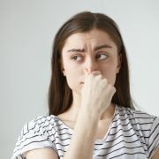 Tips for bad brethe Image depicting a person covering their mouth, symbolizing the concept of bad breath and its potential causes.
