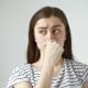 Image depicting a person covering their mouth, symbolizing the concept of bad breath and its potential causes.